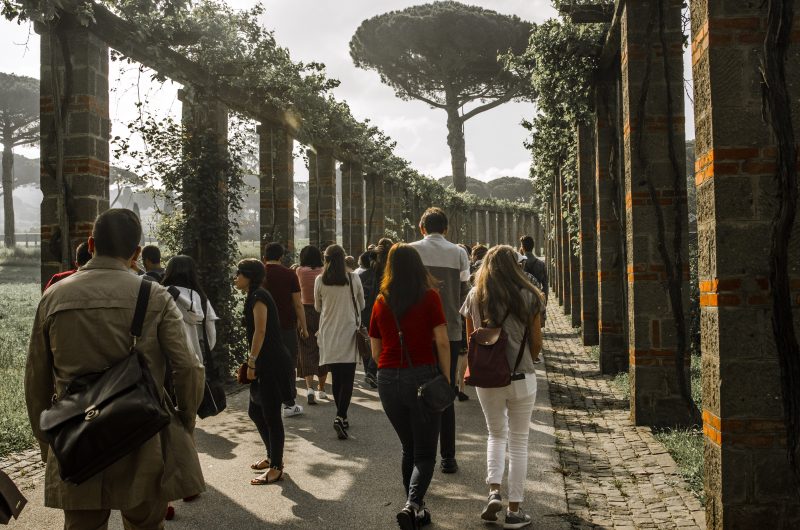 Image depicts students walking through the ruins in Italy on a Gilson trip