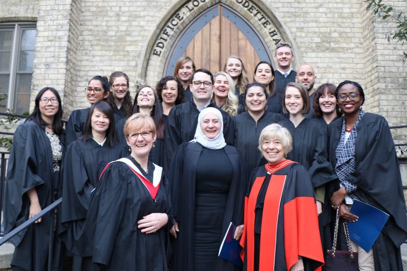 Graduates of the St. Michael's CSR program stand together on the steps of Odette Hall.