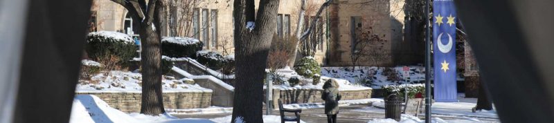 Image depicts a student walking towards Brennan Hall