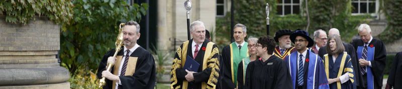Image depicts UofT and USMC staff walking into Convocation hall for Convocation
