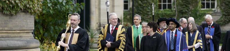 Image depicts UofT and USMC staff walking into Convocation hall for Convocation