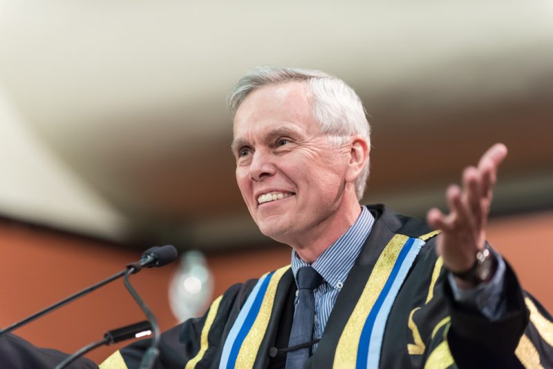 Image depicts President David Mulroney addressing students at convocation