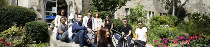 Image depicts students sitting on the steps of Brennan Hall
