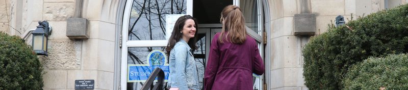 Image depicts two students walking onto Brennan Hall