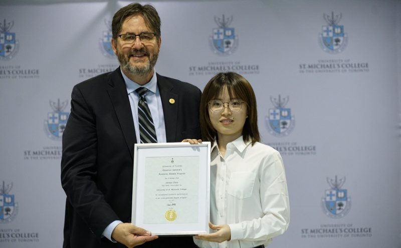 St. Michael's President David Sylvester presents 2019 graduate Jinman Zhao with the St. Michael's nomination for the Governor General's Silver Medal. 