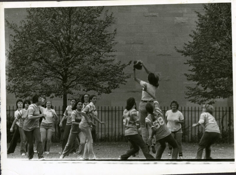 Women play football on campus in this archival image from the early 1970s. 