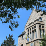 Image depicts the southern facade of Brennan Hall on a sunny summer day.