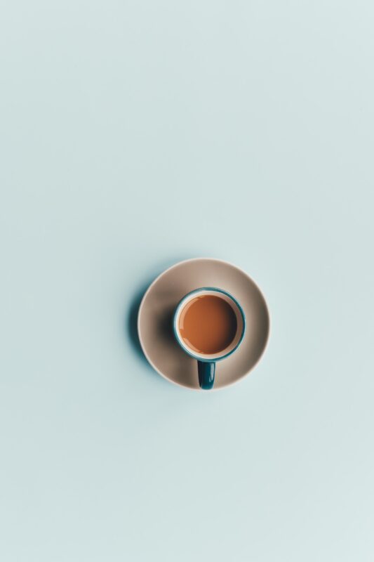 A coffee cup sits on a table, viewed from directly above. 