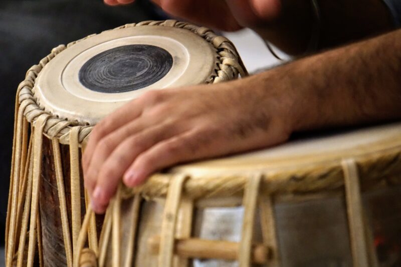 A close image of a person drumming on bongos 