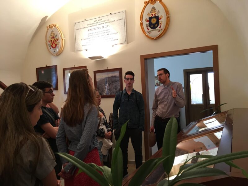 Image depicts Dr. Adam Hincks, SJ speaking to a group of St. Michael's students during a tour of the Vatican Observatory. 