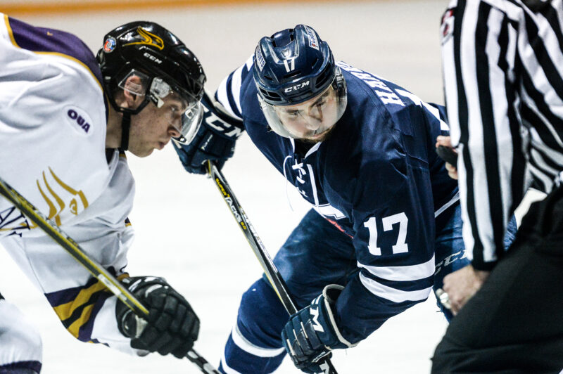 Image depicts St. Michael's student and Varsity Blues Men's Hockey forward Curtis Harvey in a face off on the ice