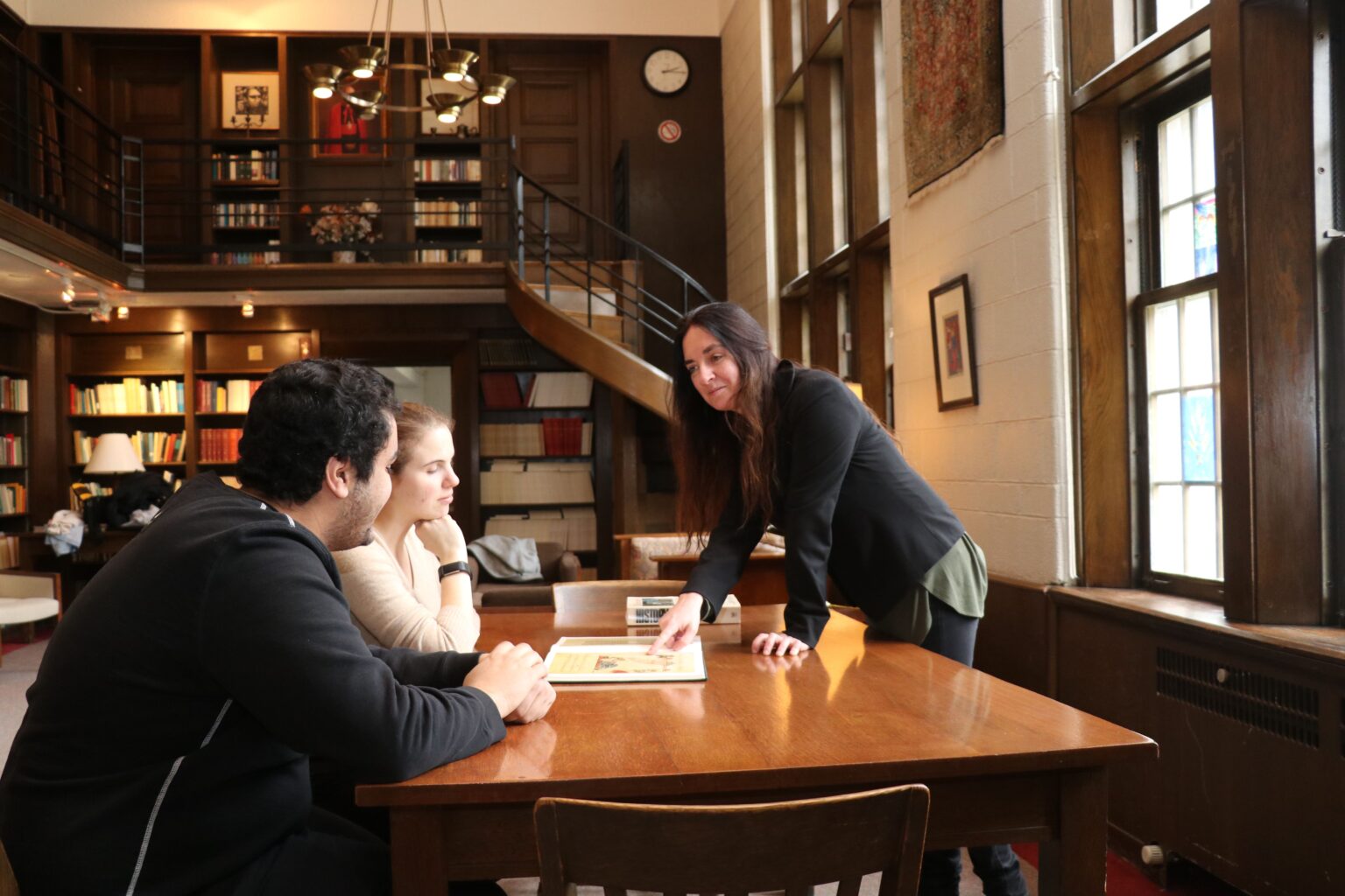 Image depicts St. Michael's prof Alison More teaching students in the Shook Common Room 