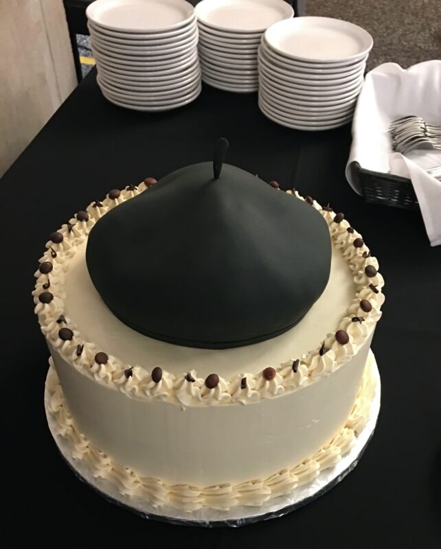 Photograph of a cake with a fondant beret on top