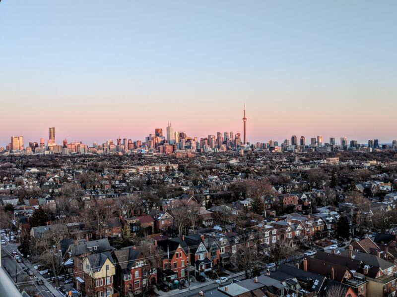 Aerial shot of the city of Toronto with a neighbourhood in the foreground.