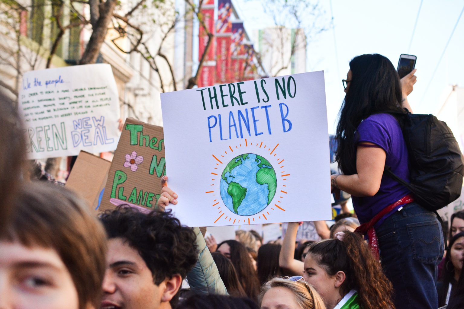 Photograph of an environmental protest with the emphasis on a sign reading "There is no Planet B"