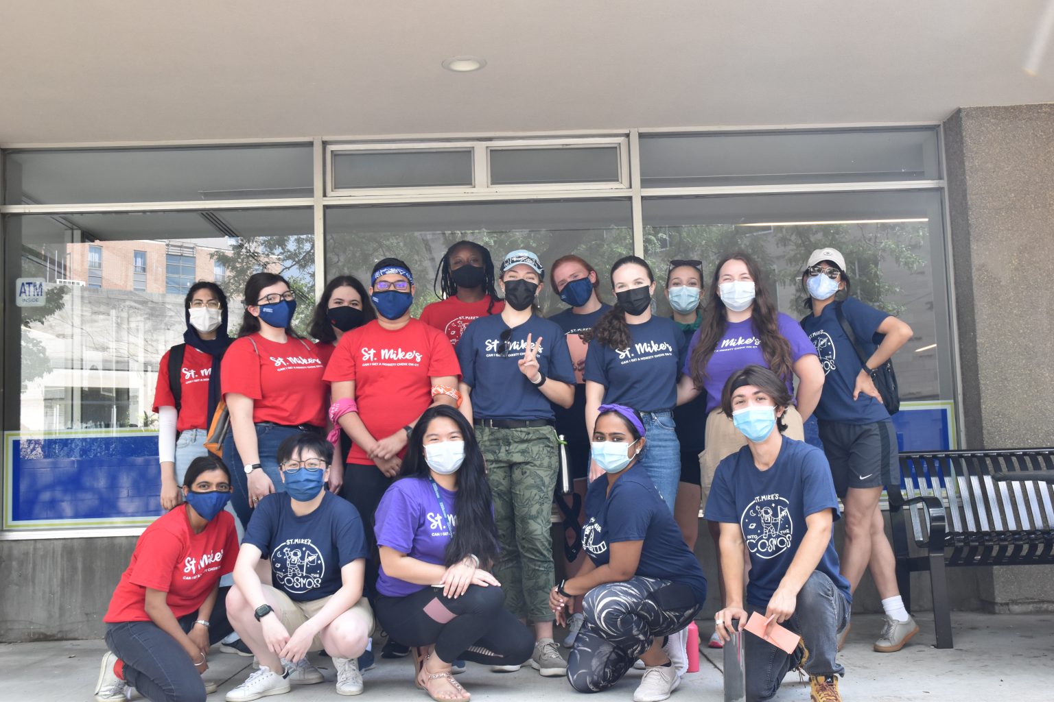 A photograph of the St. Mike's Orientation leaders, masked and posed in front of the COOP in Brennan Hall