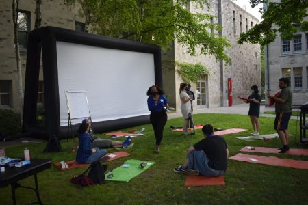 Students outdoors in front of a projector screen