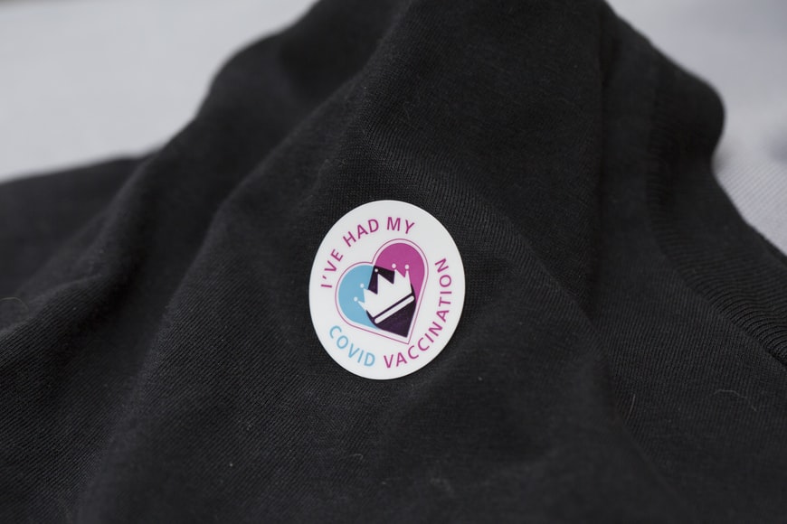 A COVID vaccination sticker on a garment