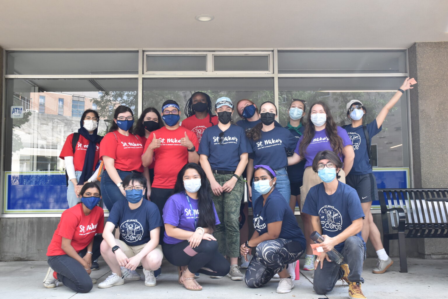 Photograph of the St. Mike's Orientation 2021 marshal team, all wearing masks St. Mike's shirts, standing in front of the Brennan COOP.