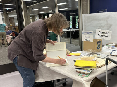 A volunteer sorts books for the sale