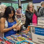 Student volunteer organizes book sale table