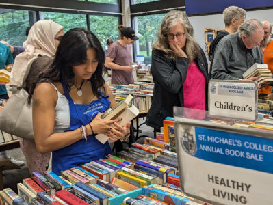 Student volunteer organizes book sale table