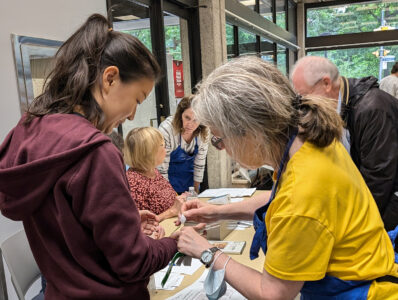 A volunteer attaches a wristband to customer