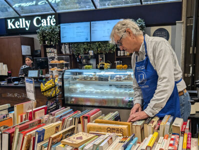 A book sale volunteer organizes the table