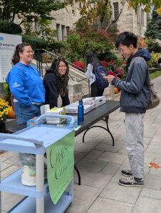 Students meet at a table outside Brennan Hall for Cleanup Day